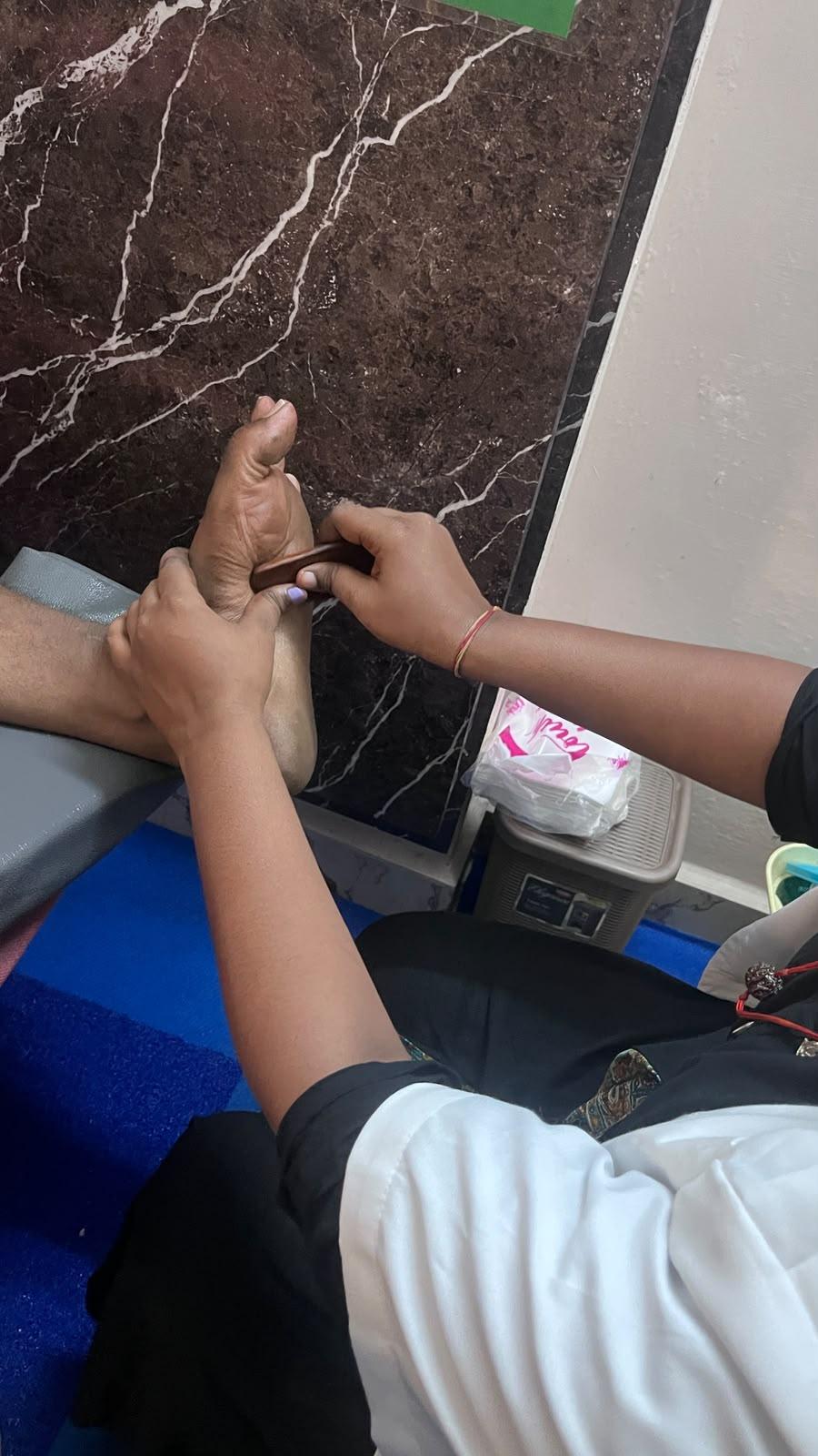 Expert reflexologist treating foot pressure points at JSV Madurai